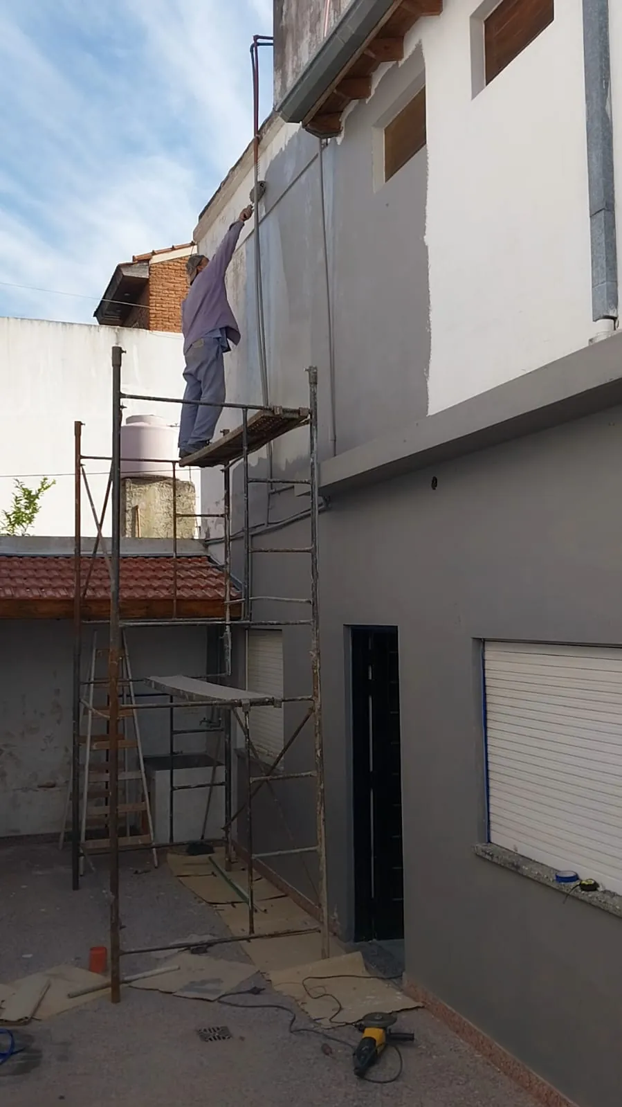 Frente de una casa en obra con andamio, trabajo de Alvarez construcciones
